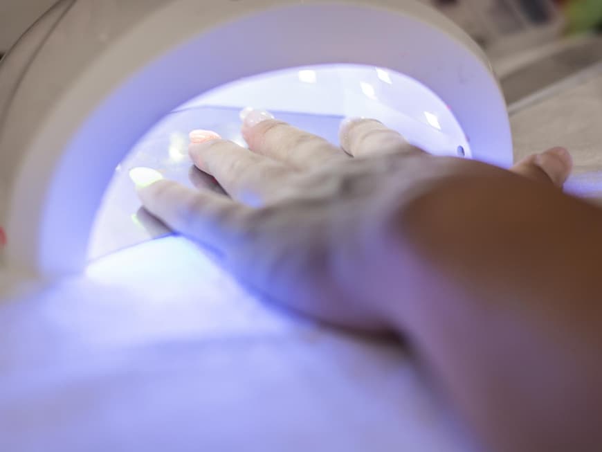 Frau haelt Hand unter UV-Licht