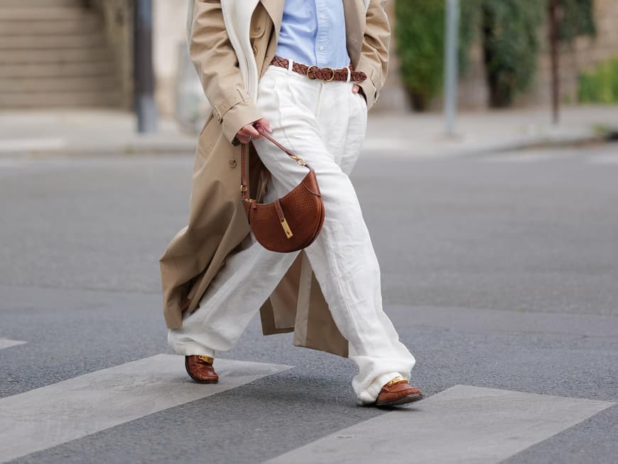 Eine Frau trägt einen Trenchcoat und Loafer