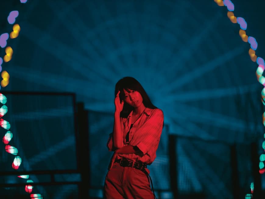 Asiatin steht in der Nacht vorm Riesenrad
