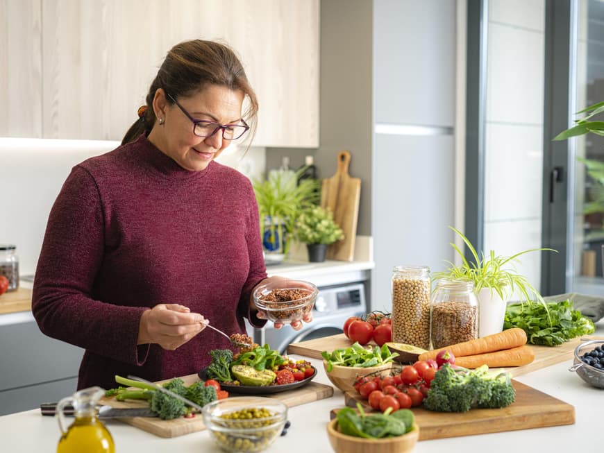 Frau bereitet in der Küche einen Salat zu