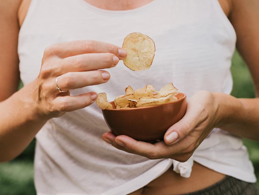 Frau isst Kartoffelchips