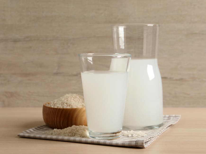 Ein Glas Reiswasser und eine Karaffe stehen auf einem Tisch