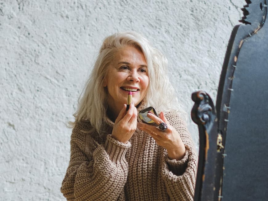 Frau trägt Lippenstift auf