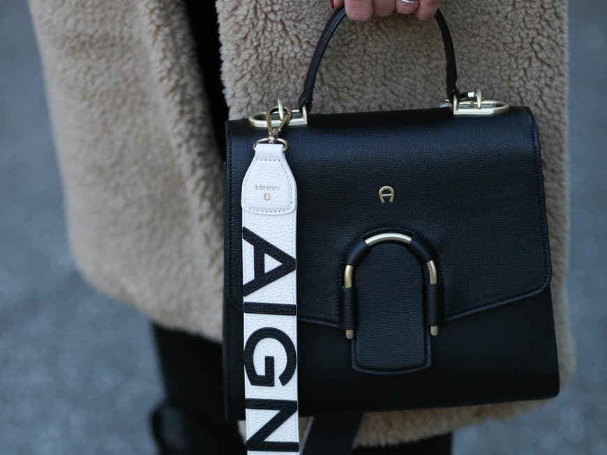 Frau trägt schwarze tasche von Aigner