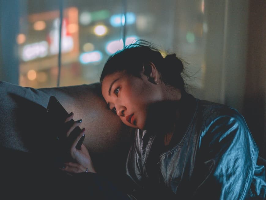 Sternzeichen, die in dieser Woche Pech haben Frau schaut traurig aufs Handy– Sternzeichen, die in dieser Woche Pech haben