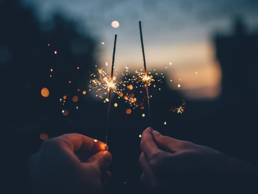 Silvester-Horoskop Zwei Menschen halten Wunderkerzen in der Hand