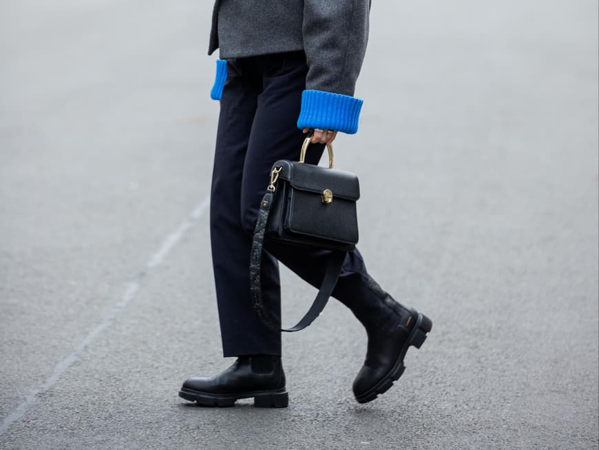Aline Kaplan trägt schwarze Aigner Tasche schwarze Boots und graue Wolljacke