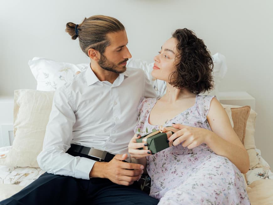 Mann und Frau sitzen auf dem Bett und gucken sich an