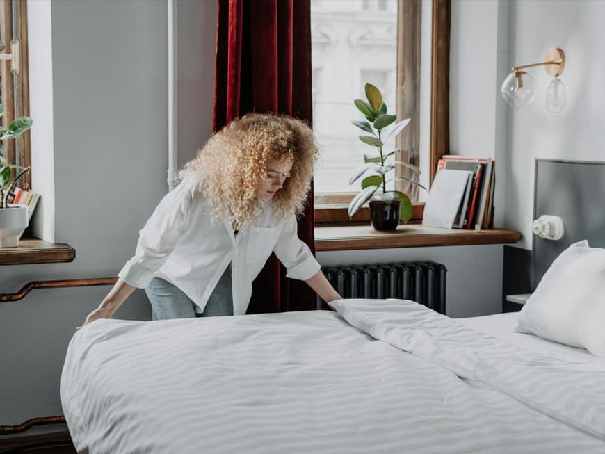 Frau macht das Bett