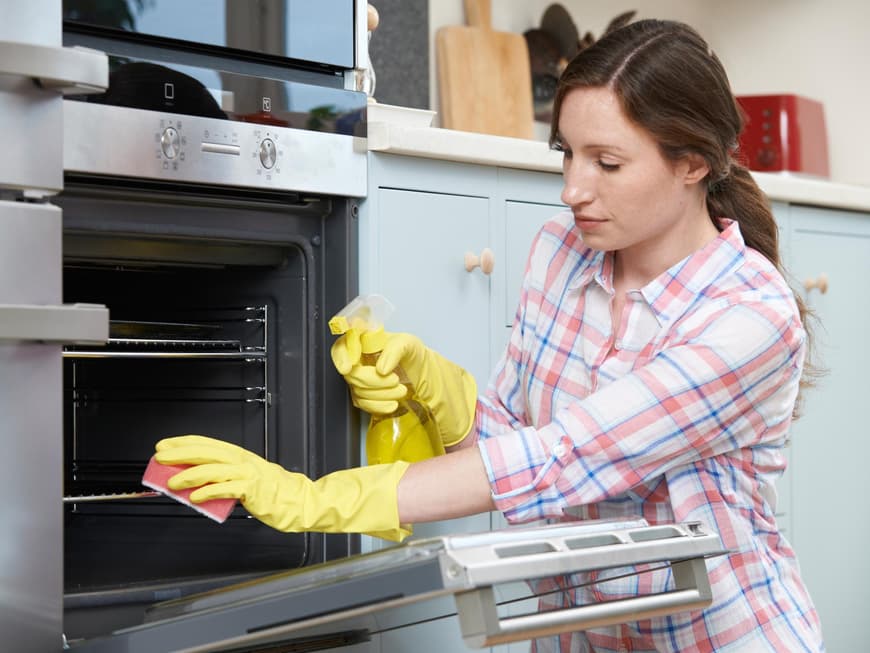 Frau putzt Backofen