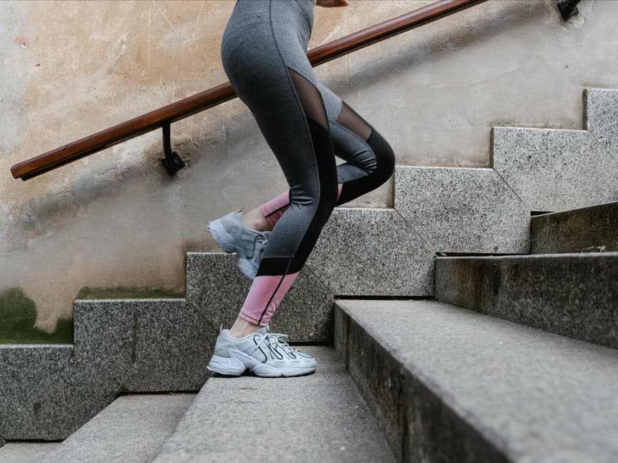 Frau trägt beim Joggen Sneaker und Sport-Leggings