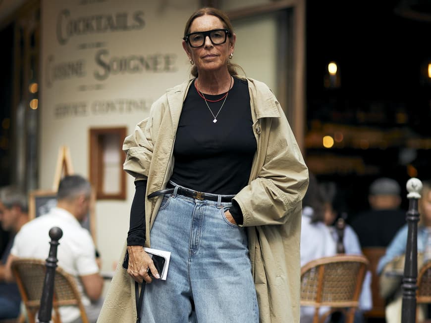 Frau trägt weite blaue Jeans mit schwarzem Blazer und Sonnenbrille sowie Jeans Top Frau trägt weite blaue Jeans mit schwarzem Blazer und Sonnenbrille sowie Jeans Top