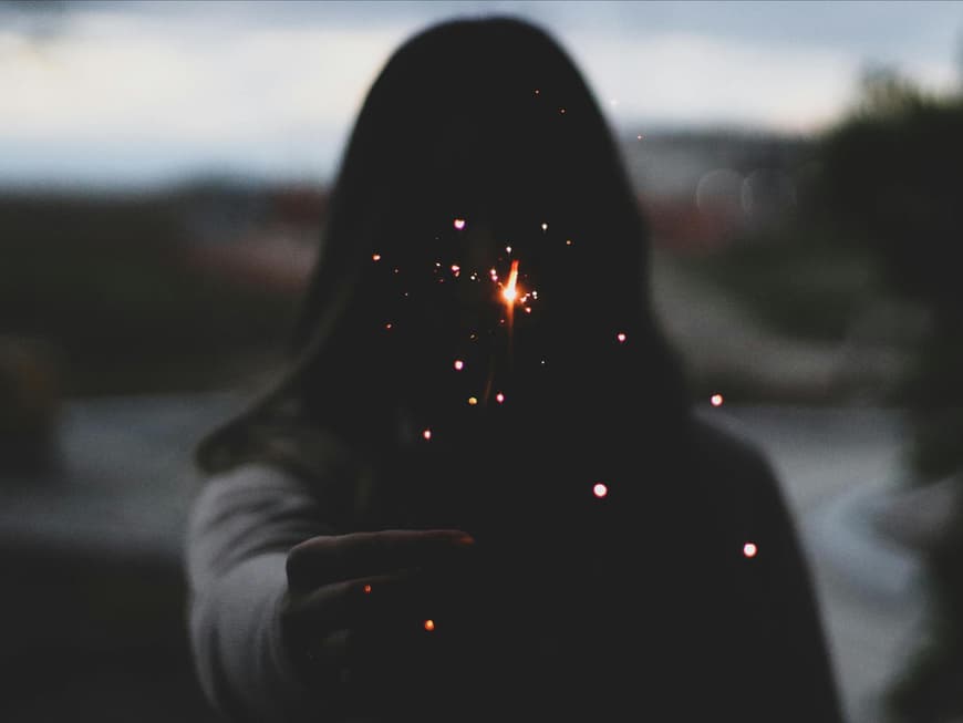 Wochenhoroskop vom 22. bis zum 28. Januar Frau hält eine Wunderkerze in der Hand