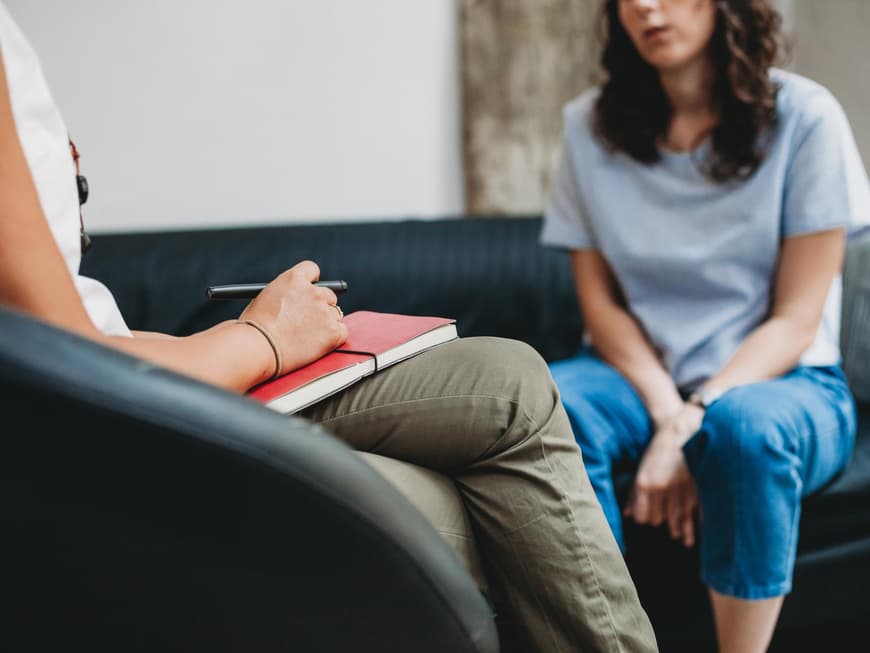 Anzeichen, dass du eine Therapie machen solltest Zwei Frauen sitzen sich gegenüber