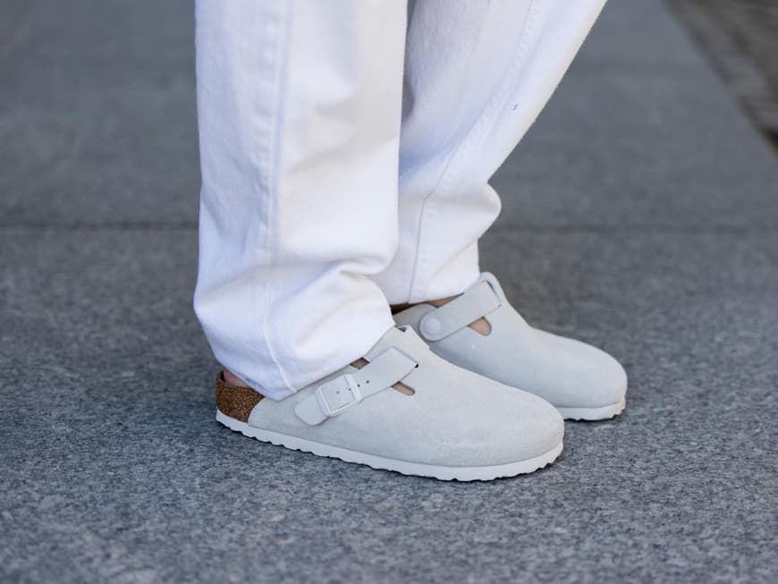 Birkenstock Boston in Grau mit einer weißen Hose kombiniert.