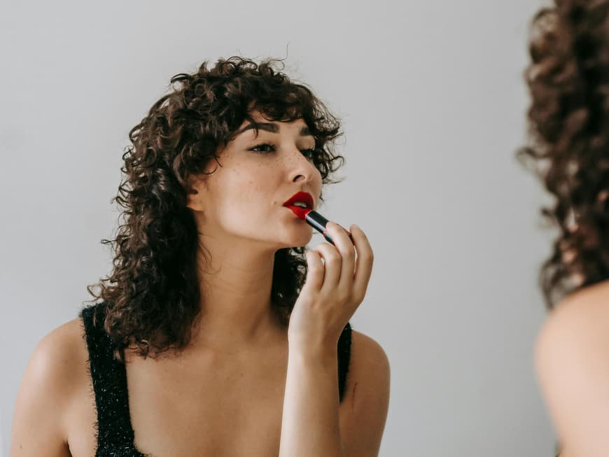 Frau traegt wasserfesten Lippenstift auf