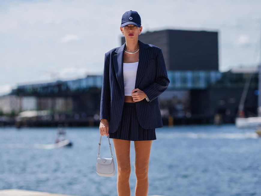 Blauer Blazer kombinieren: Styling-Tipps Frau kombiniert blauen Blazer mit Cap