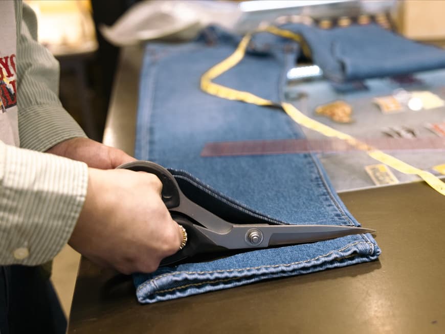 Person kürzt eine Jeans