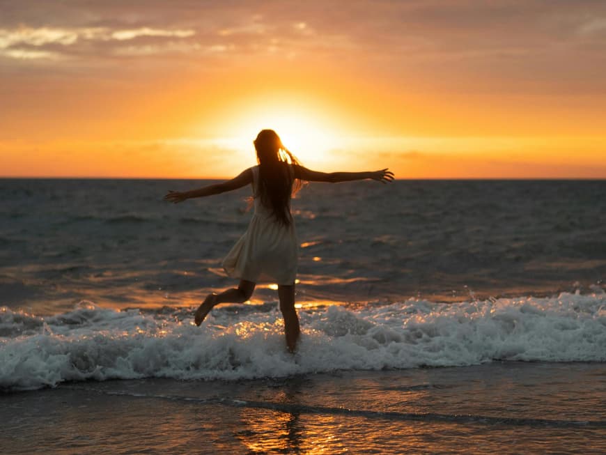 Frau im Meer beim Sonnenuntergang