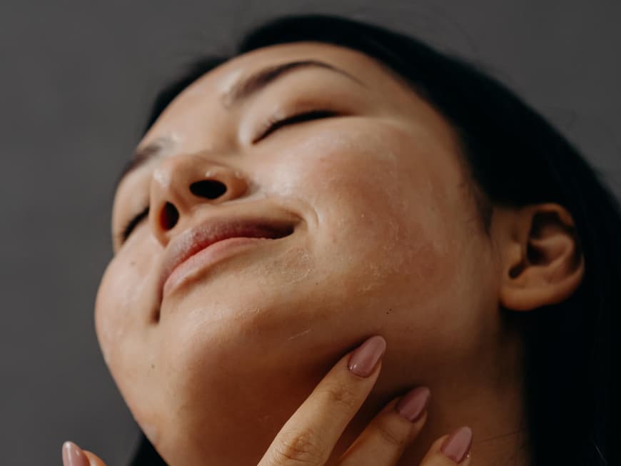 Sonnencreme fuer Allergiker Frau traegt Sonnencreme auf