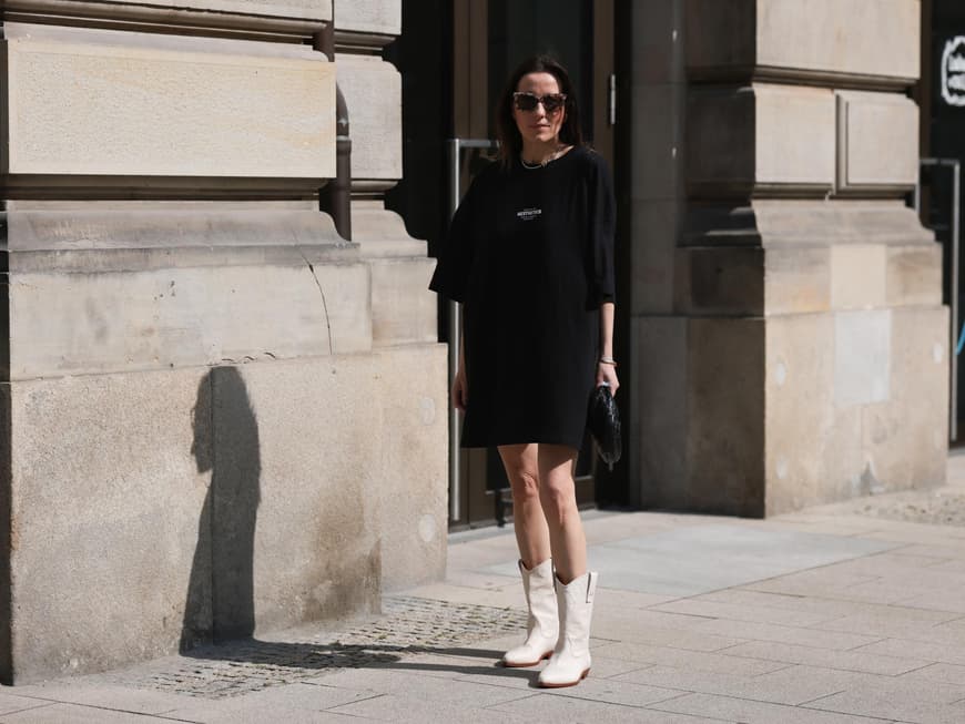 Kleid mit Stiefeln kombinieren Frau in T-Shirt-Kleid mit Stiefeln