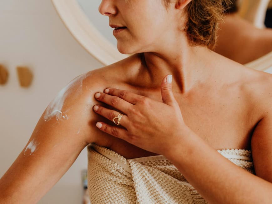Die besten Bodylotions für Frauen ab 50 Frau cremt sich ein
