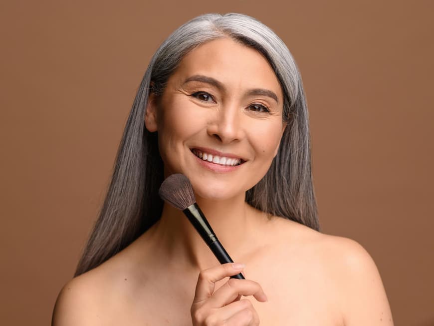 Ältere Frau mit Make-up Pinsel