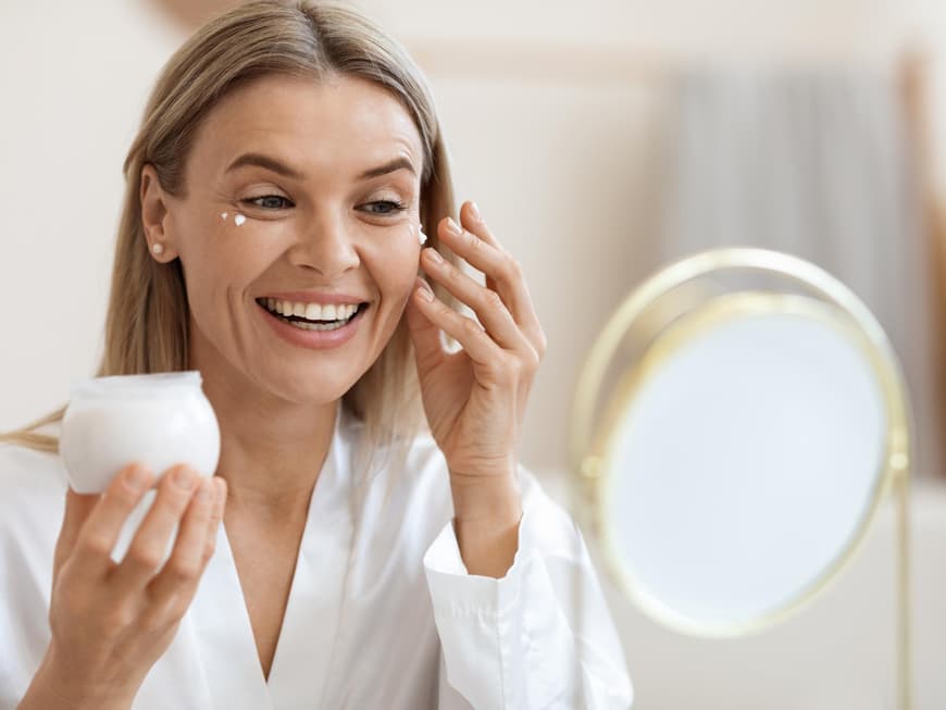 Botox-Creme gilt als Alternative zu Injektionen. Frau trägt Gesichtscreme auf.