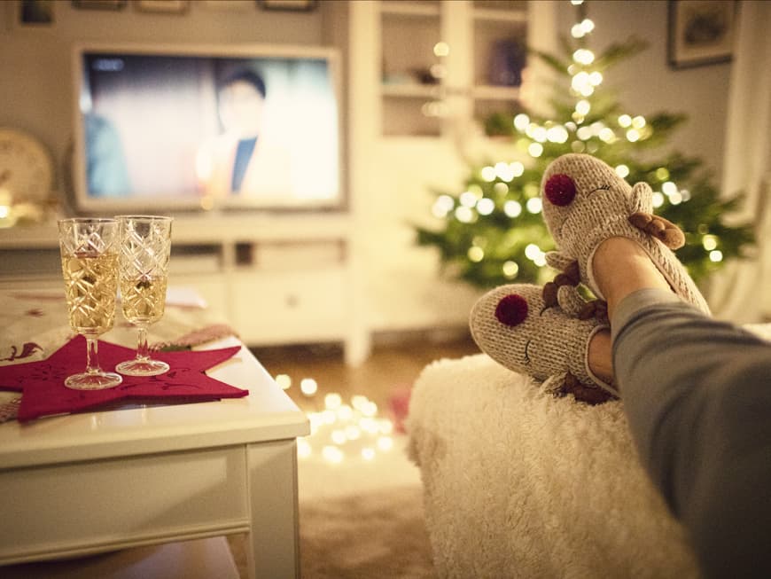 Welcher Weihnachtsfilm zu deinem Sternzeichen passt, liest du hier. Frau guckt Weihnachtsfilm