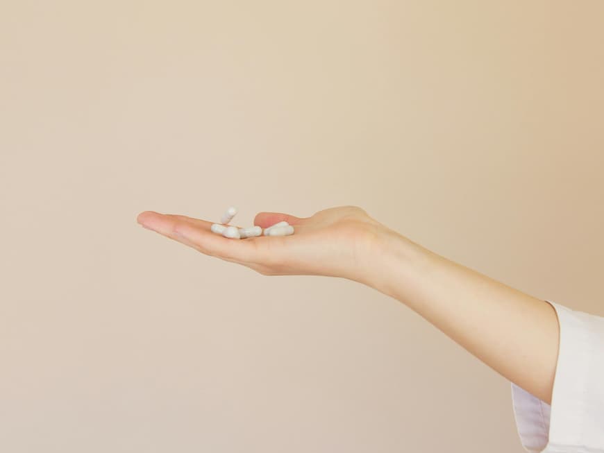 Frau hält Tabletten in der Hand.