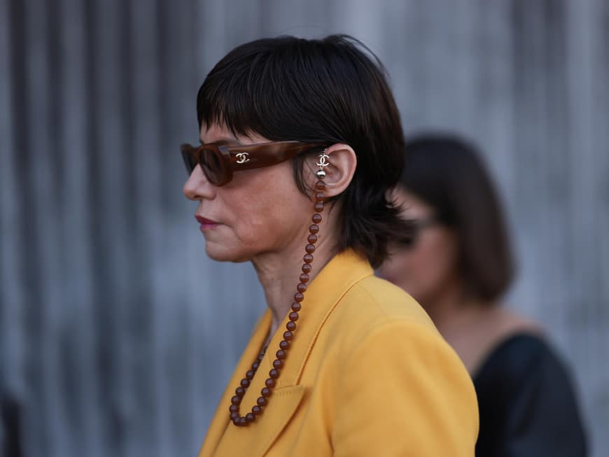 Frau von der Seite trägt einen Mixie Cut und eine Sonnenbrille.