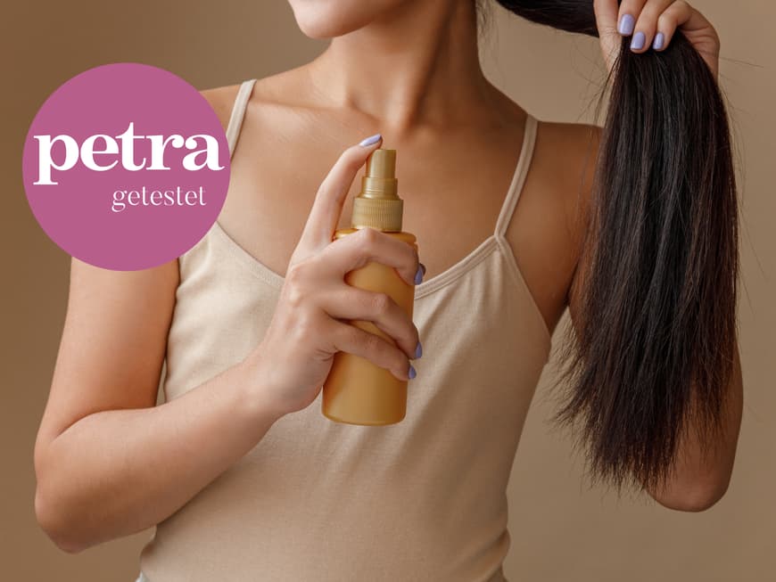Frau sprüht Haarspray auf Längen