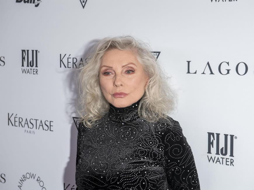 Debbie Harry mit einem schwarzen, hoch geschlossenen Kleid mit Glitzersteinen.