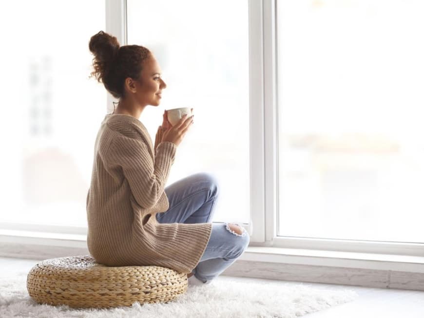 Junge Frau genießt den Ausblick aus dem Fenster
