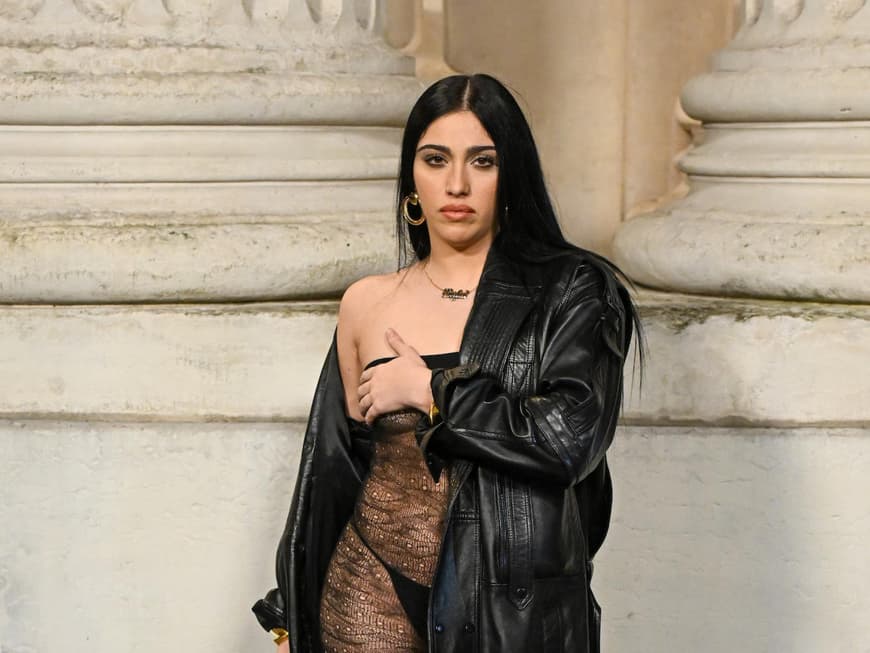 Lourdes Leon zeigte sich auf der Pariser Fashion Week in einem freizügigen Outfit. Lourdes Leon in einem transparenten Kleid mit Leder-Trenchcoat.
