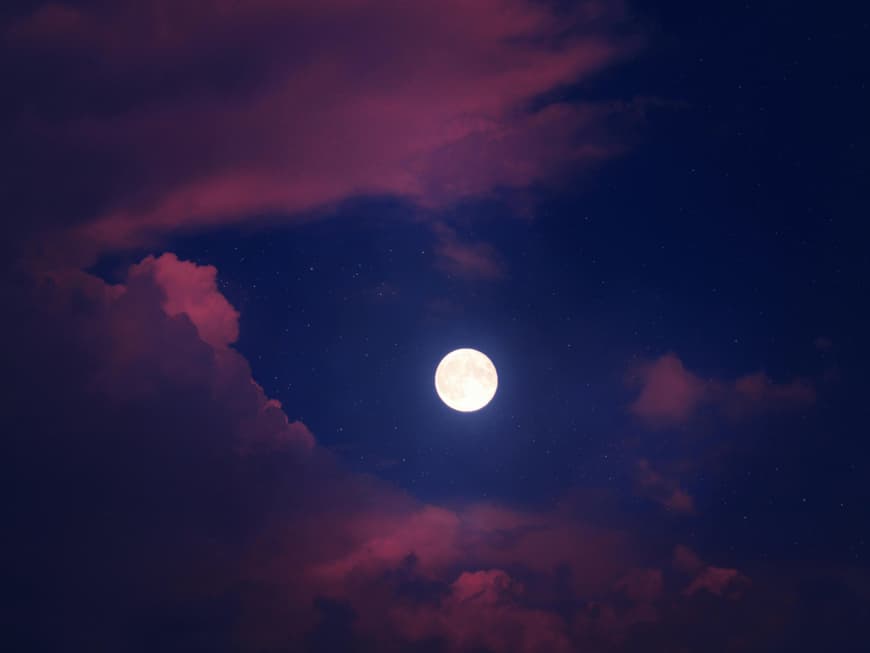 Das Wochenhoroskop für dein Sternzeichen Mond am Himmel mit rosa Wolken