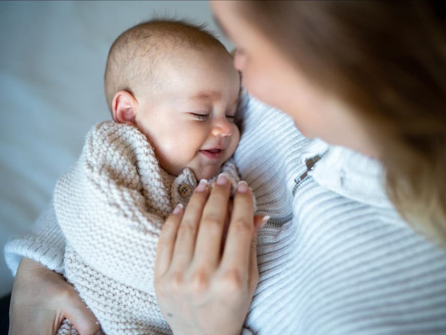 Mutter hält ihr neugeborenes Baby im Arm