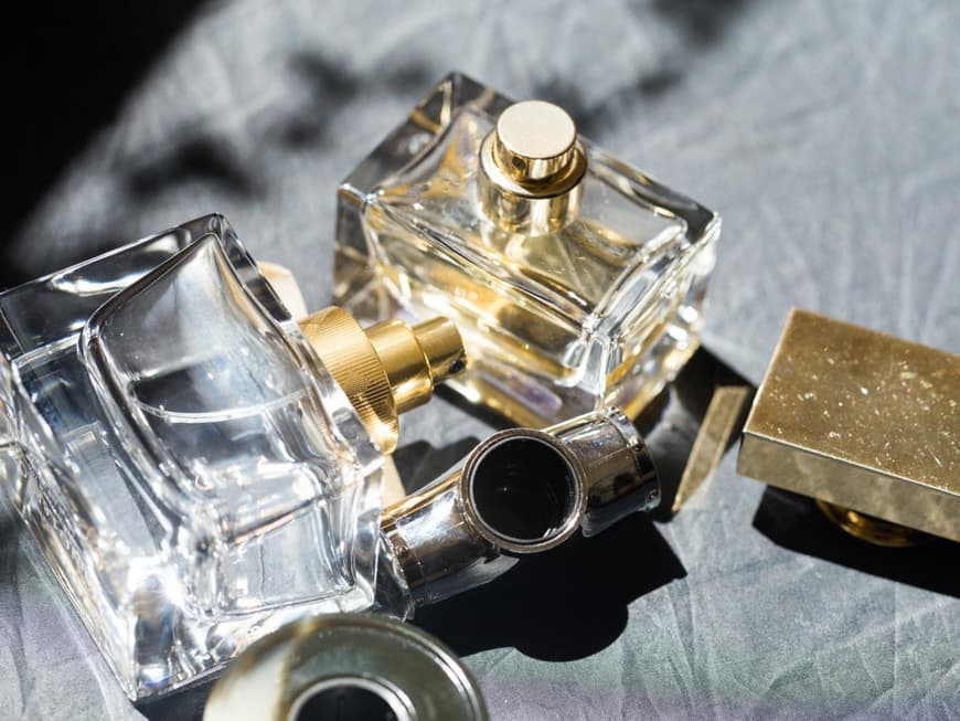 Parfum Flakons liegen auf einem grauen Hintergrund.