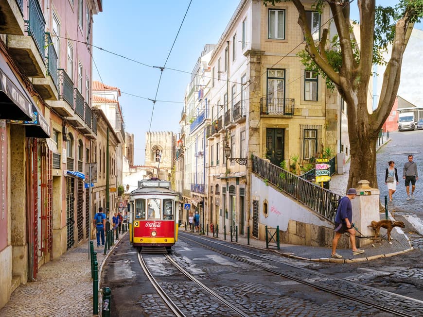Eine Tram fährt in Alfama den Berg herunter.