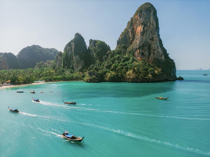 Krabi ist in Thailand ein tolles Reiseziel. Die Küste von Krabi mit grünen Felsen und türkisblauem Meer und Booten.