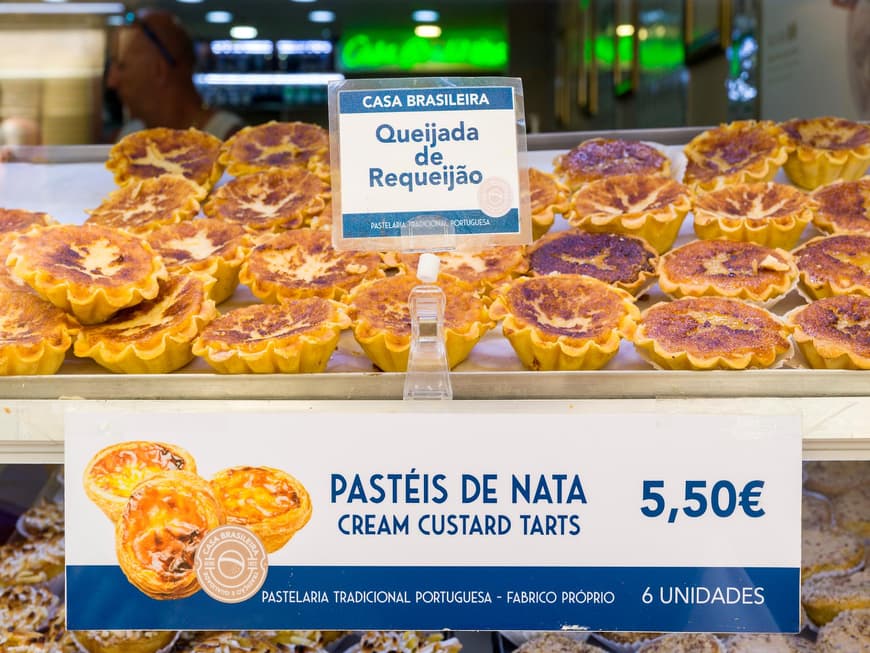 Pasteis de Nata hinter einer Glasscheibe in einer Bäckerei.
