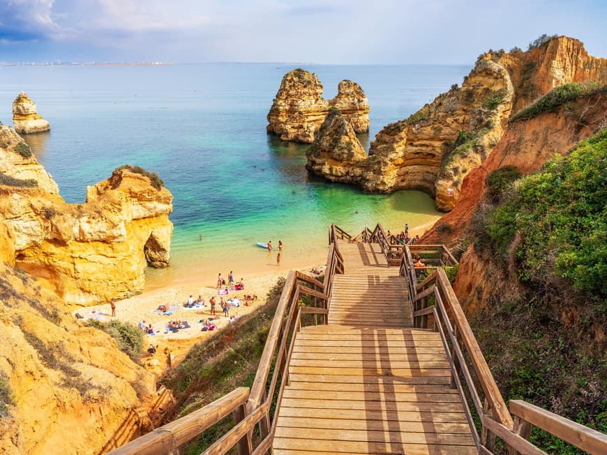 Ein Blick auf eine Holztreppe, die zum Camilo Beach herunter führt mit Menschen am Strand.