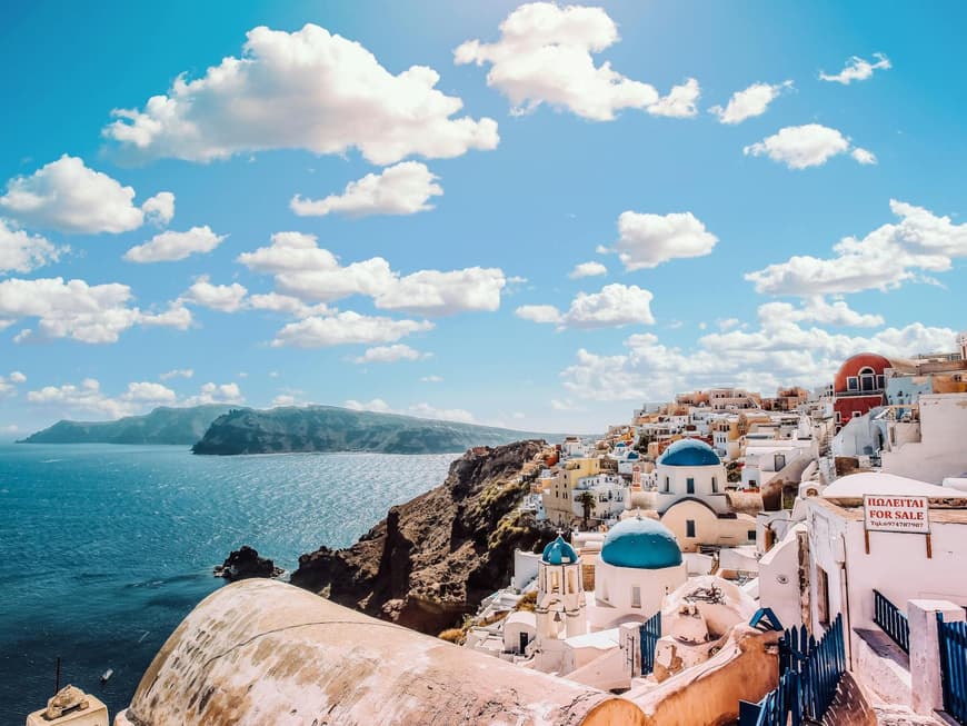 Santorini hat viele süße Häuser zu bieten. Bunte Häuser von oben an der Küste zum Meer