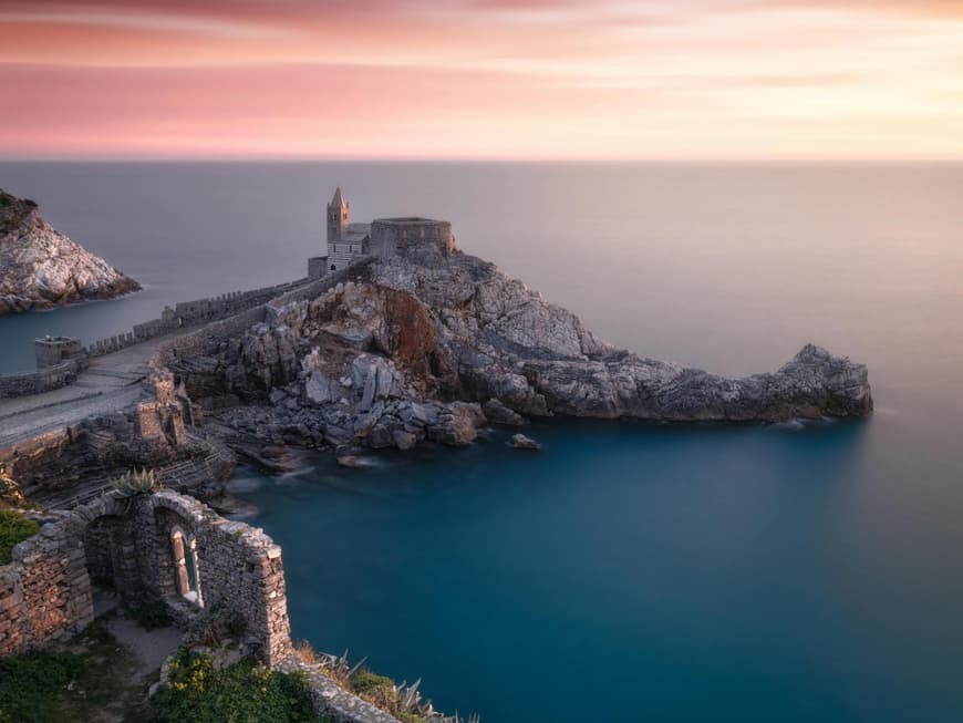 Ein Blick auf eine Burg auf einem Felsen direkt am Meer bei Abenddämmerung