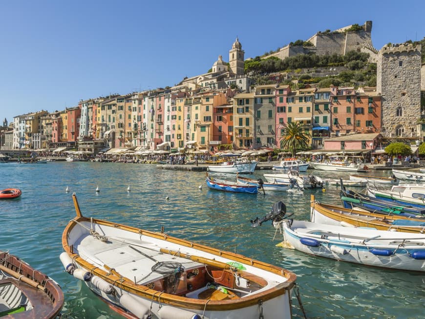 Ein Blick auf bunte Häuser und den Hafen von Portovenere mit kleinen Fischerbooten.