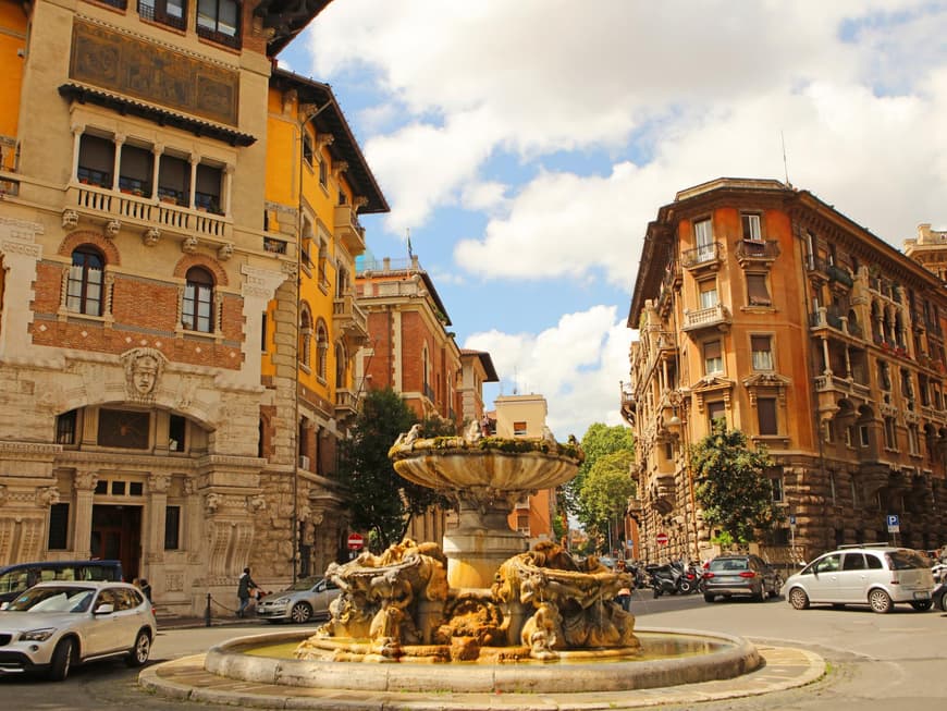 Das Quartiere de Coppede ist nicht so überlaufen. Das Quartiere de Coppede in Rom mit gelben alten Häusern und einem Brunnen in der Mitte.