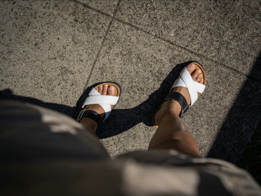 Dieses Produkt von dm verhindert die Entstehung von Blasen an den Füßen. Frauenfüße in Sandalen