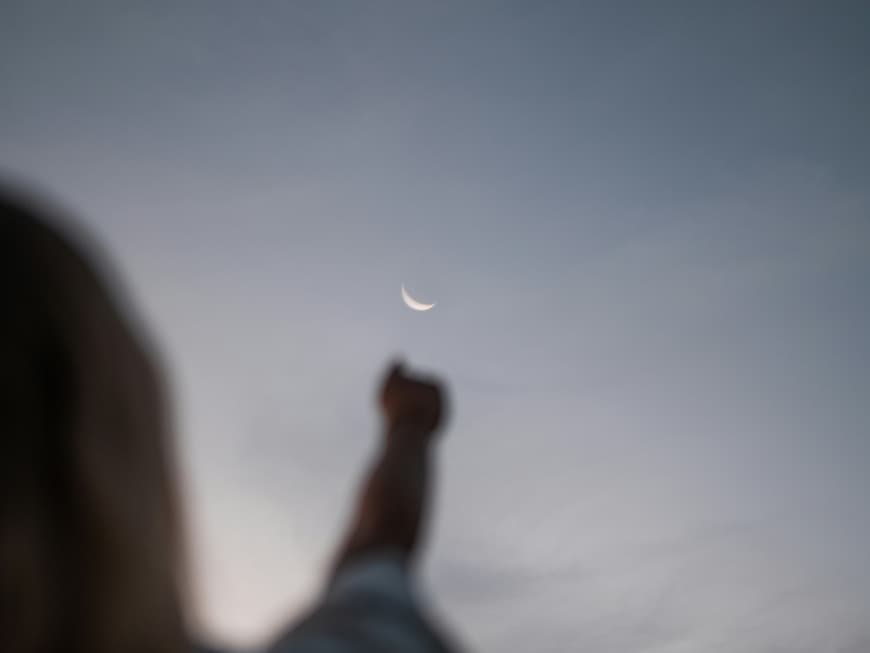 Für diese 3 Sternzeichen wendet sich heute alles zum Guten. Frau streckt Arm in den Himmel