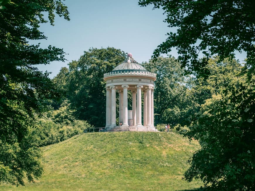 Ein Blick auf einen Pavillon aus Stein auf einem Hügel in einem großen Garten.