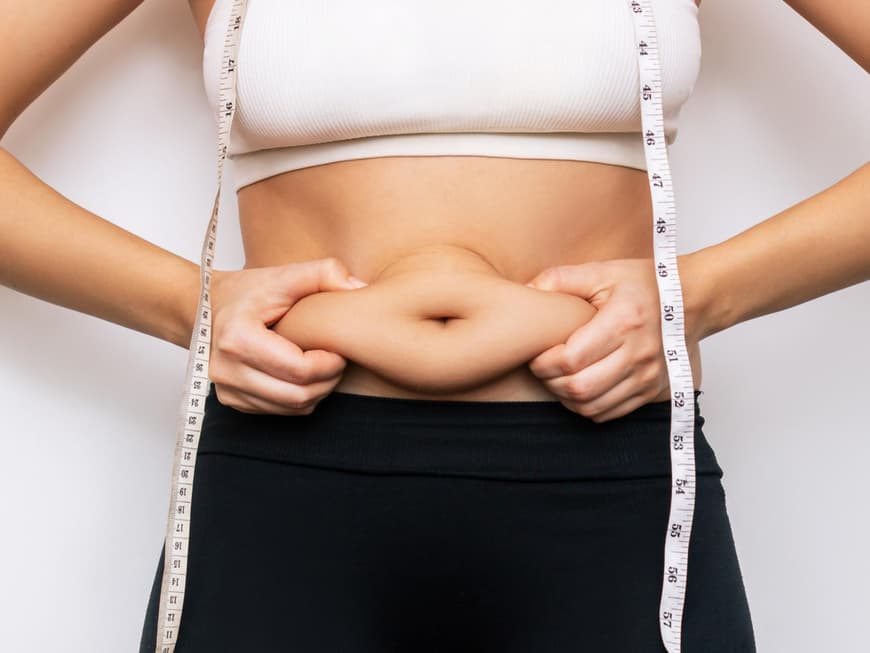 Eine Frau hält sich den Bauch